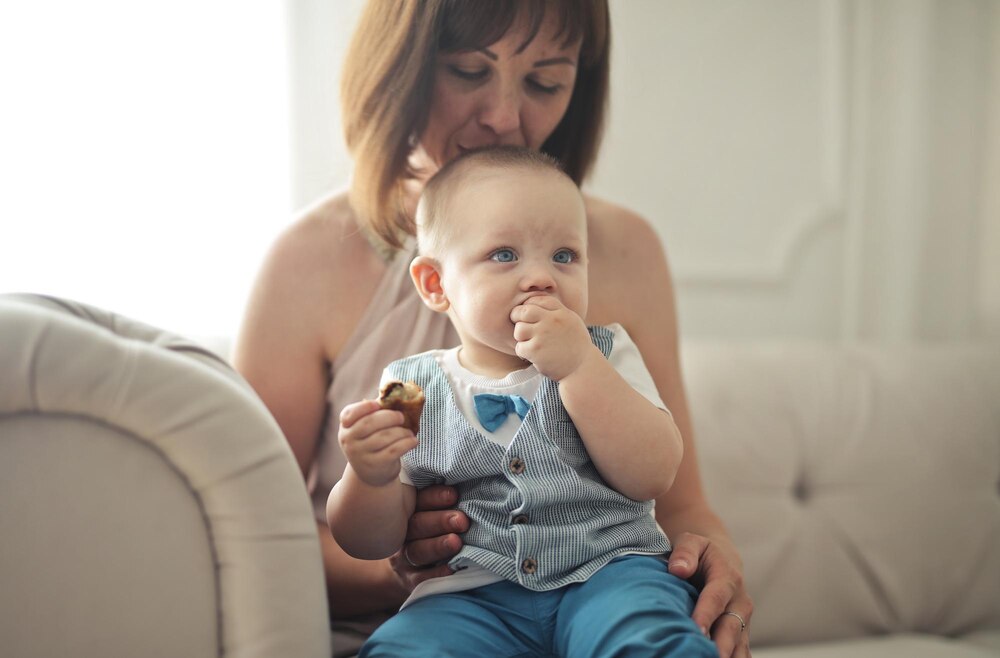 mother kisses her son sitting on the sofa